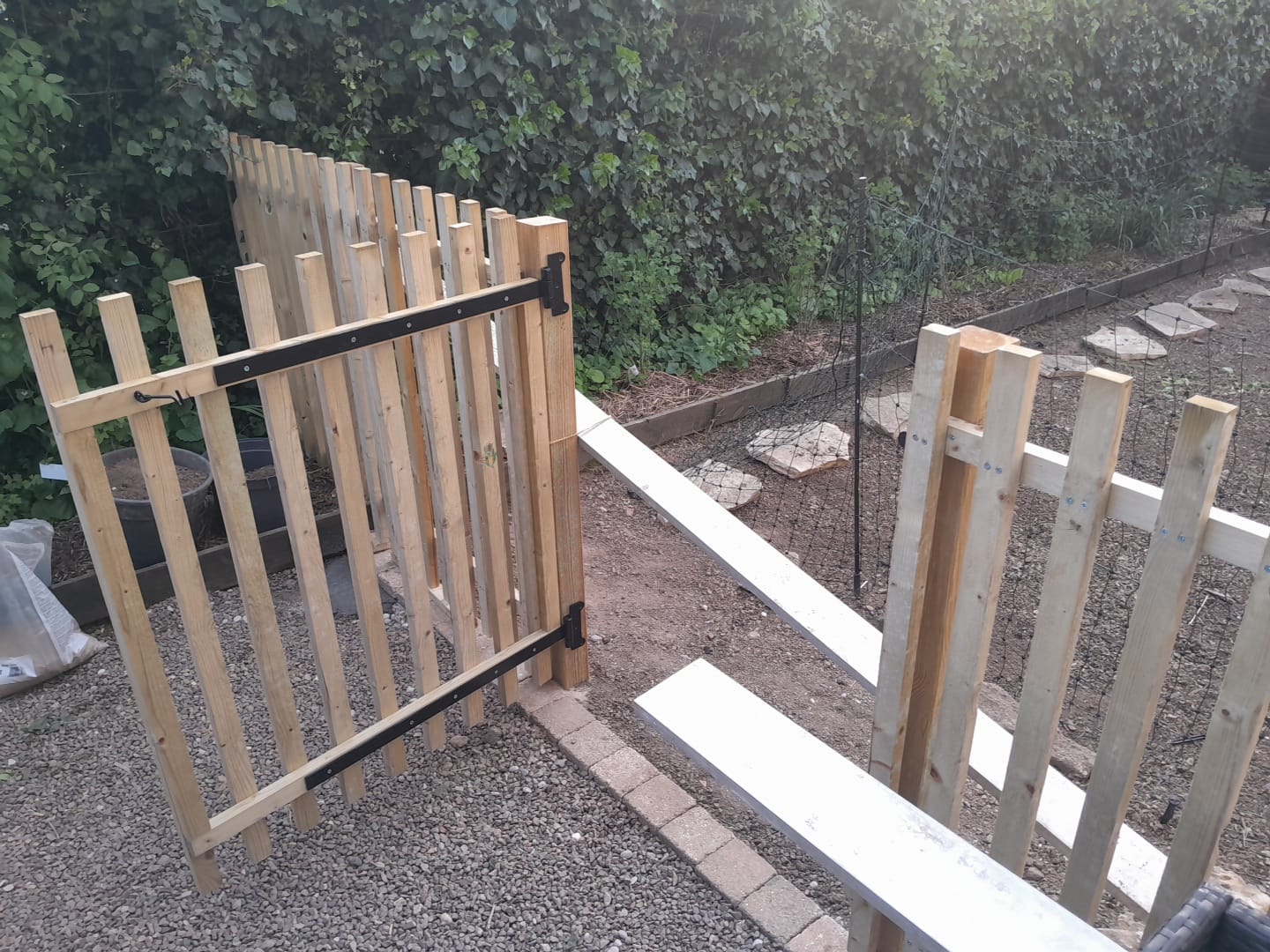 Pose de portillon et clôture en bois dans un jardin